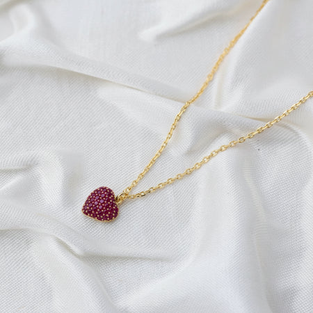 Gold necklace with a red heart-shaped pendant 